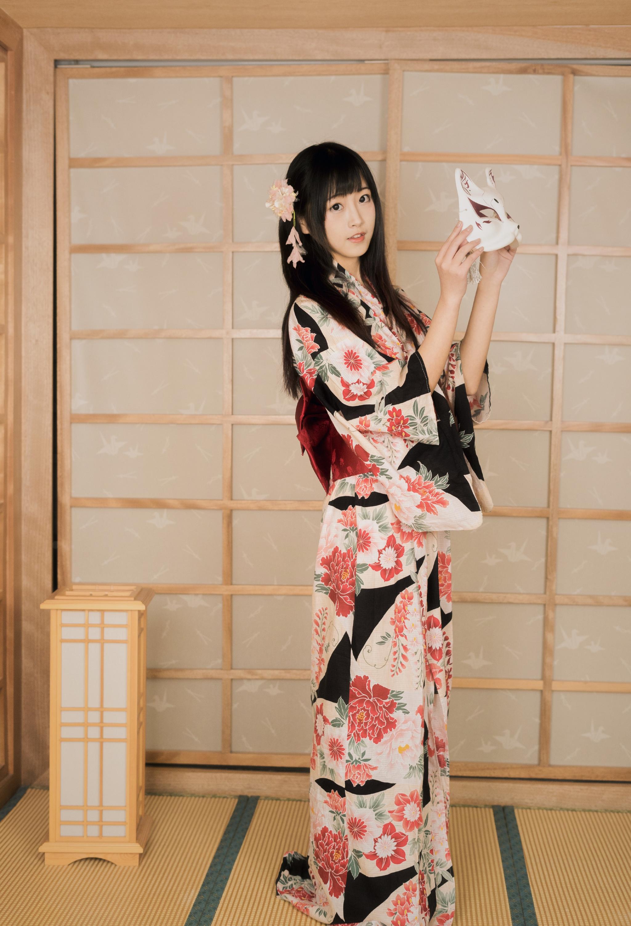她身穿着花色的和服,缠腰的布带后面一个方形的包包