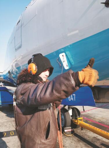 哈尔滨机场地勤机务员用耳麦和机长"聊天"