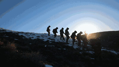 大风中他们携手前行只因手中迎风招展的五星红旗