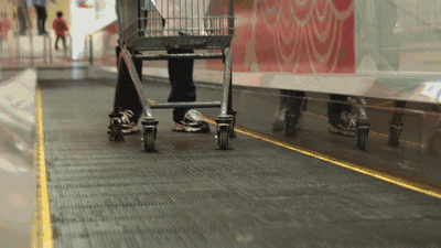 超市里把小孩放在手推车上的家长要注意了 上自动扶梯可能有危险