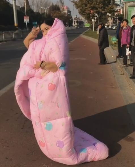 美女裹着被子出门等公交,表情特别的悠然引围观!