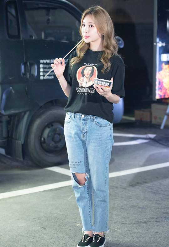 金亚荣身穿一件黑色短袖上衣,下身搭配一条破洞牛仔裤,显得她的腿笔直