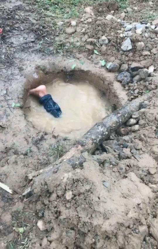 积满水的地洞浑黄无比小伙头上脚下钻进去还真抓起鱼来