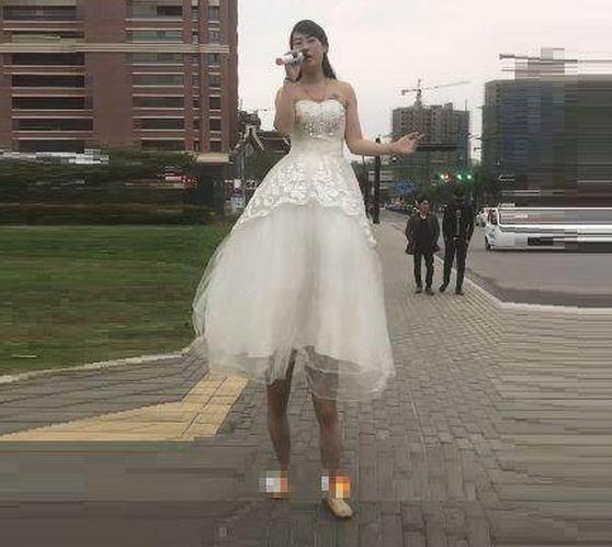 街头两米高女巨人卖唱,吸引不少路人眼光,结果被人当众拆穿