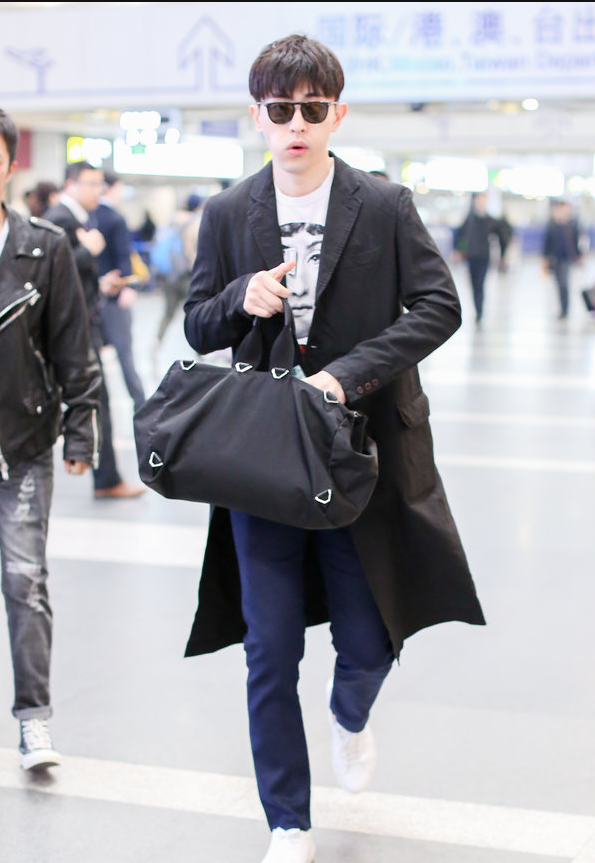 邓伦穿黑色风衣现身机场 拎黑色大包包简约有型