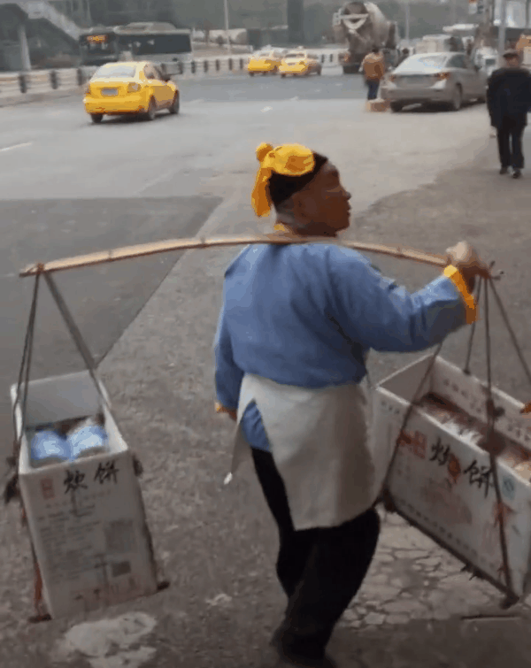 "武大郎"重庆街头挑担买饼 引路人侧目