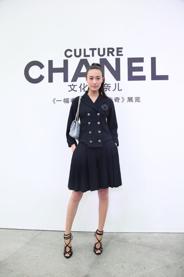 一件白色宽大毛衣,脚踩一双橘黄色小皮鞋,手中拎着黄色包包,时尚新颖