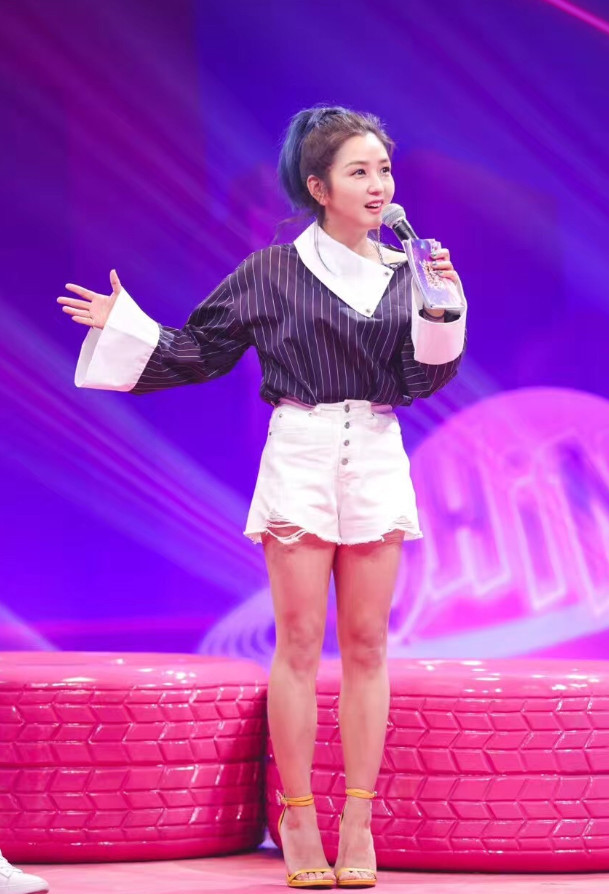 何洁身穿一款条纹上衣,打破一款白色短裤,脚踩一双黄色高跟鞋,看起来