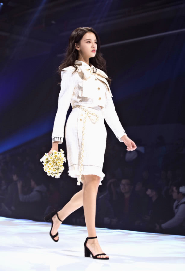 孙珍妮身穿一款黑色上衣,搭配一款青色高腰短裙,看起来十分简约个性