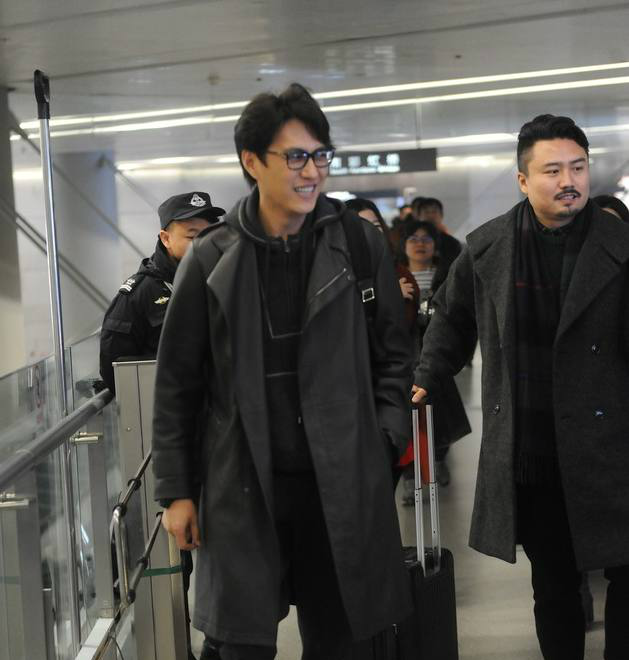 靳东身穿风衣戴黑框眼镜现身机场