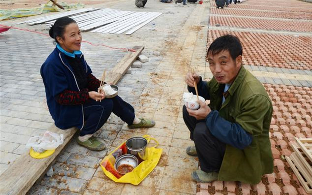 一組農民工蹲地吃飯圖,碗裡看不見肉,只求能吃飽