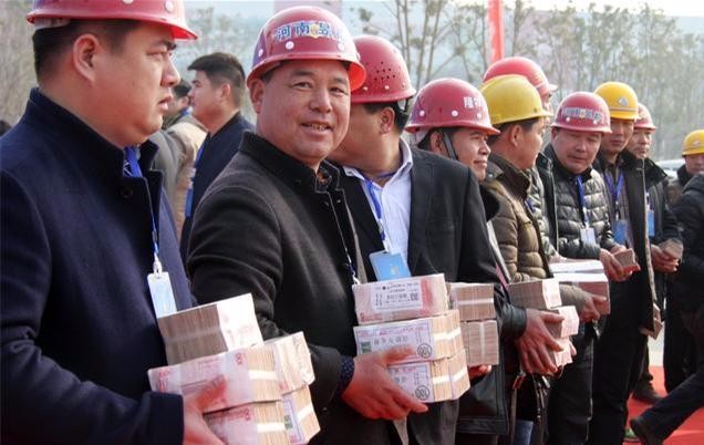 2000万现金堆积成小山状,农民工们一一上台领取工资.