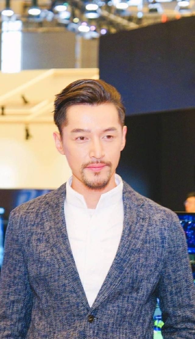 胡歌身着灰色西装出席活动 蓄起胡须举手投足间魅力十足