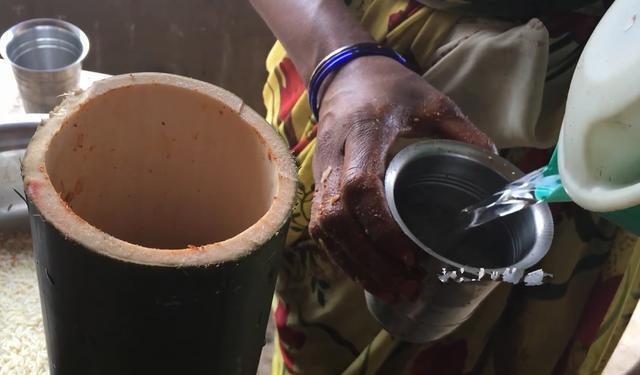 竹筒里放上水之后,把放了鸡肉和米饭的竹筒放在炭上烤,一直烤到竹筒变