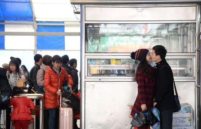 火车站,上演着分别的一幕.一对情侣在进站时依依惜别.