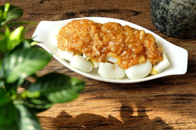 8,拌好的蒜泥汁盖在鹌鹑蛋上,吃的时候拌一下就可以了;看着这浓浓的蒜