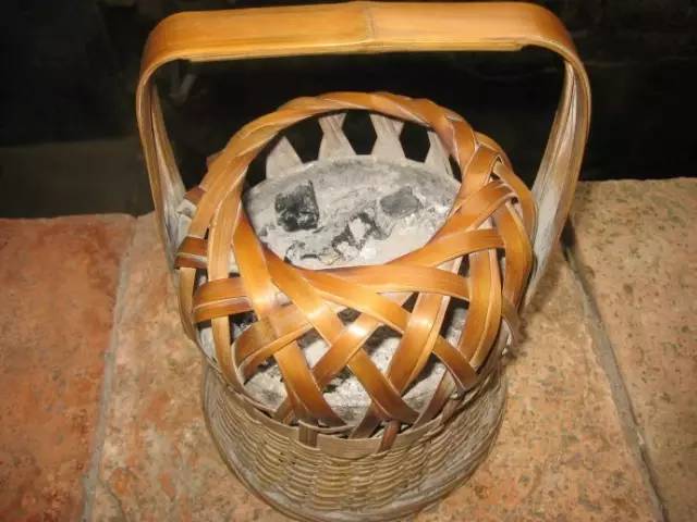 外面是篾,竹扎的笼子,里面是 盛放碳火的土陶器皿.