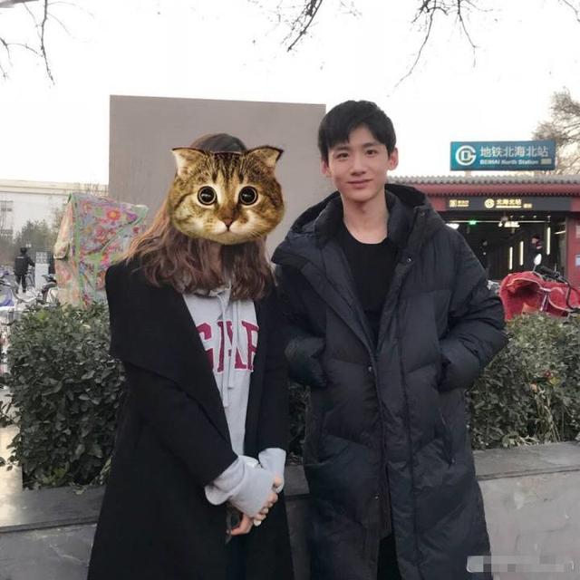 白敬亭穿长款羽绒服与粉丝合照,双手插兜敞着怀很帅气