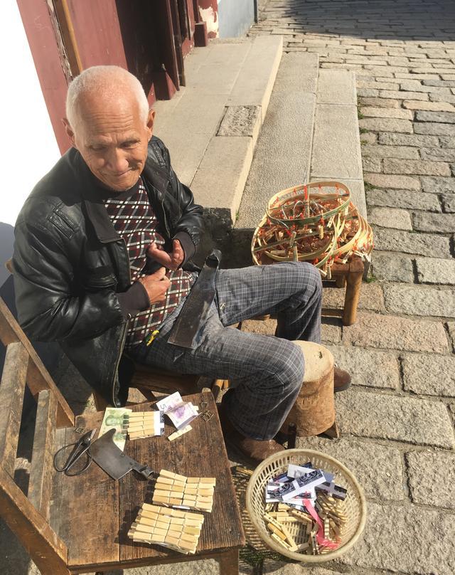 80岁老人坐古镇街头现做现卖手工竹夹大受欢迎游客扔钱就走
