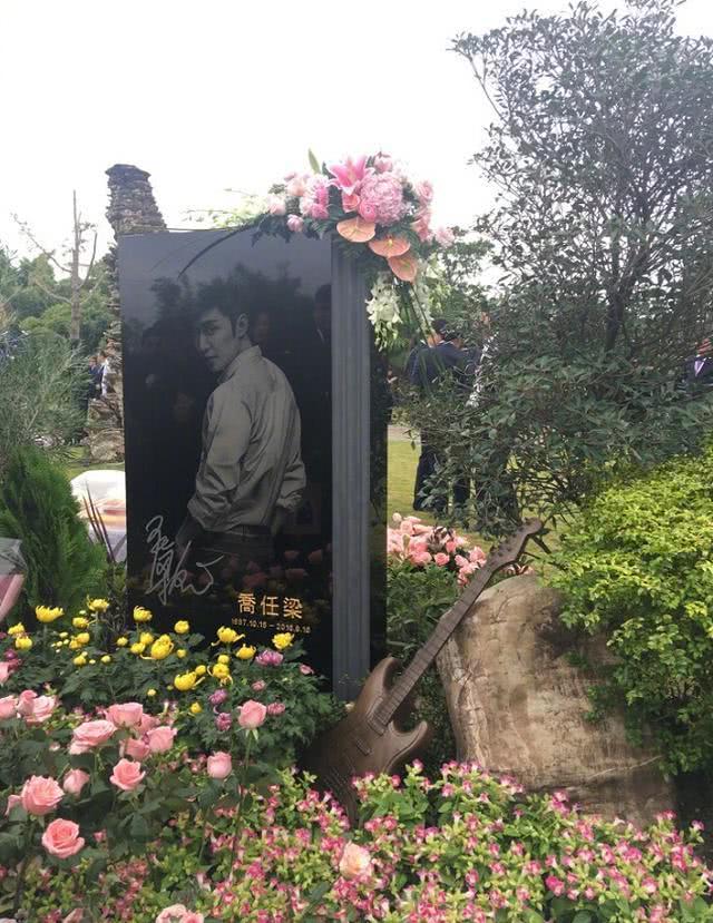 而乔任梁墓碑上,也镶嵌有一张照片,旁边还有一个他喜爱的吉他.