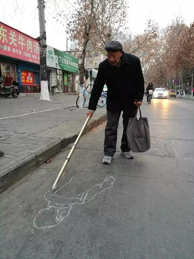 洛阳退休老人在马路路面上粉笔素写画行人速写人生百态