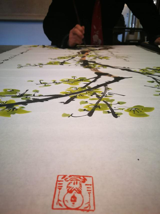 毛笔先蘸淡绿色,笔尖蘸浓绿色点出花瓣花蕾.