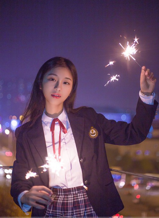 华灯初上校服妹妹手握烟花点缀夜景照