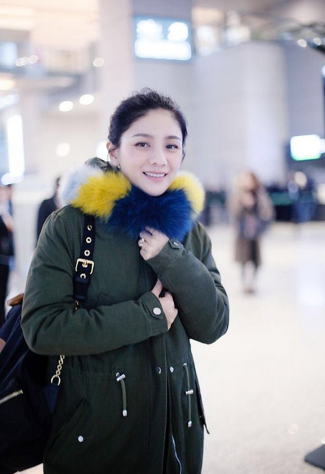42岁胡可现身机场,彩虹领大衣凹出少女感,真的是两个孩子的妈?
