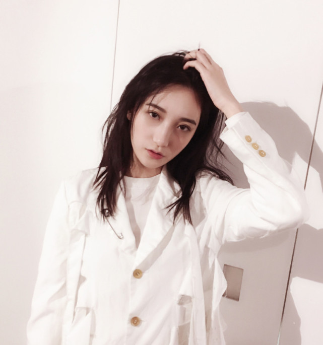 拍摄硬照时蒋思羽身穿白色上衣加蓝色阔