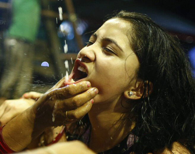 尼泊尔妇女不顾形象争相抢喝"圣酒"