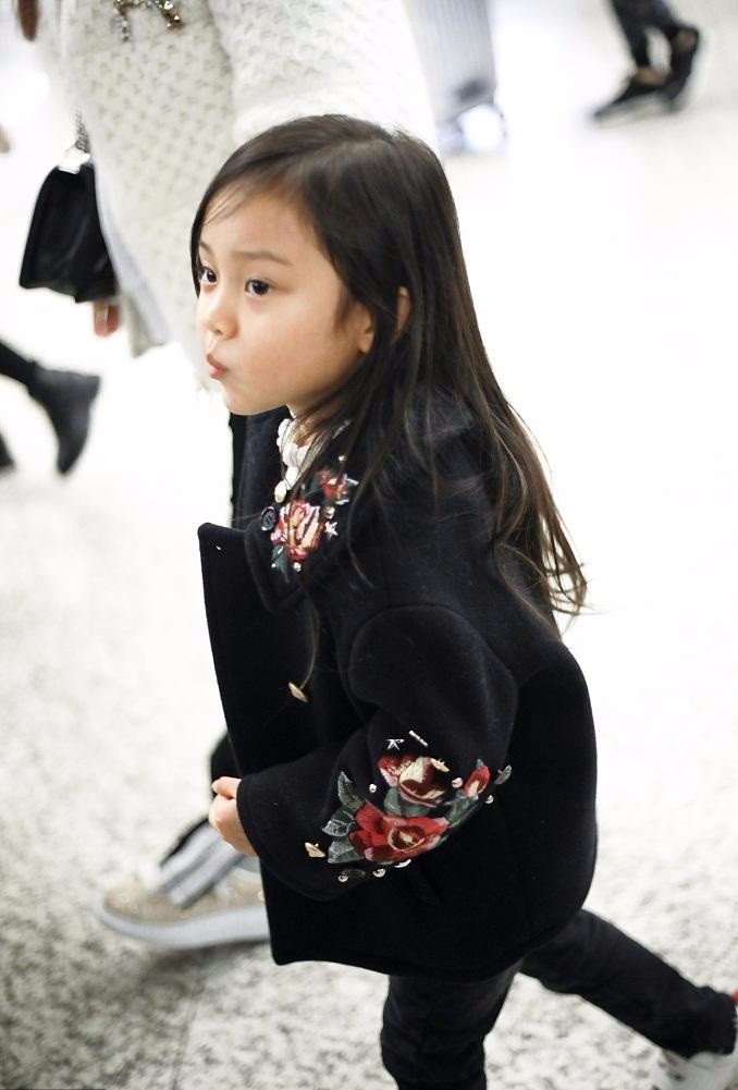 照片种小甜馨身穿黑色刺绣外套,黑色长发,俨然成为大姑娘,看见镜头后