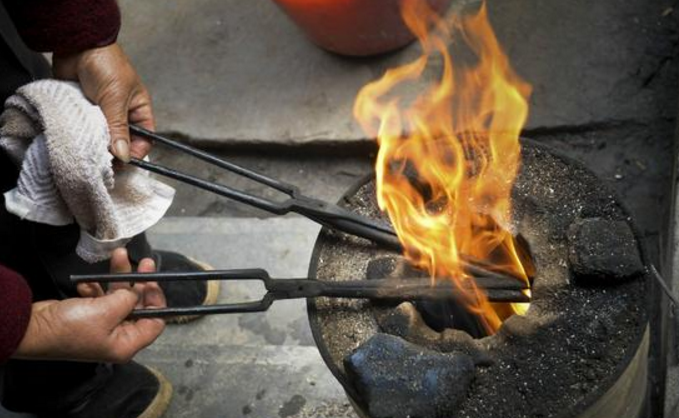 老人把火钳烧红了来给顾客"烫发",门口排队的顾客却络绎不绝