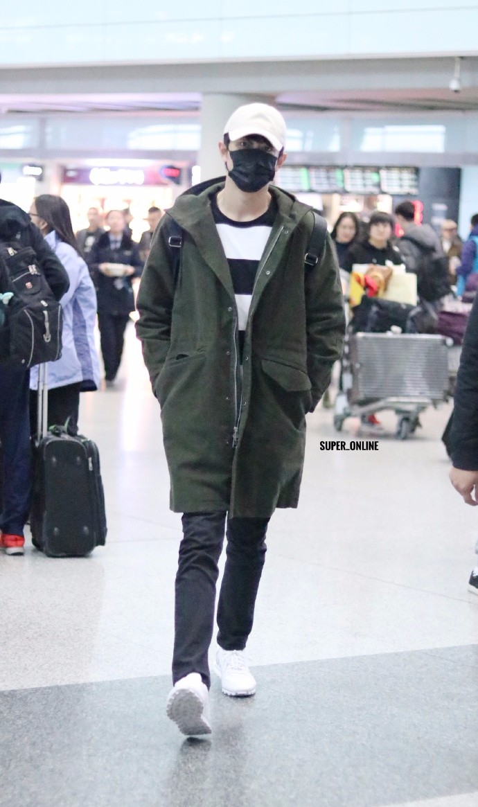 林更新穿军绿色大衣口罩遮面现身机场,双手插在衣服口袋酷劲十足