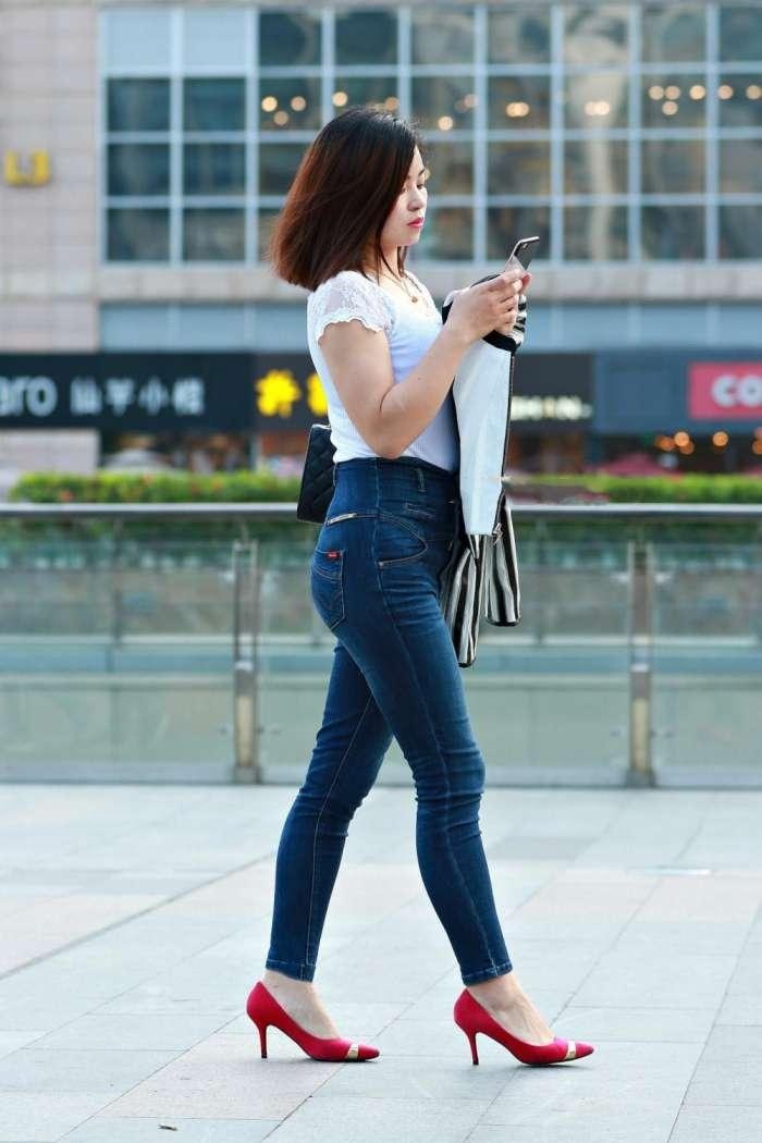 街拍穿紧身牛仔裤配分红高跟鞋的美女,圆润曲线吸睛