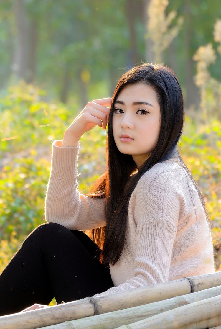 冬日阳光下一个长发飘飘的青春美丽女孩