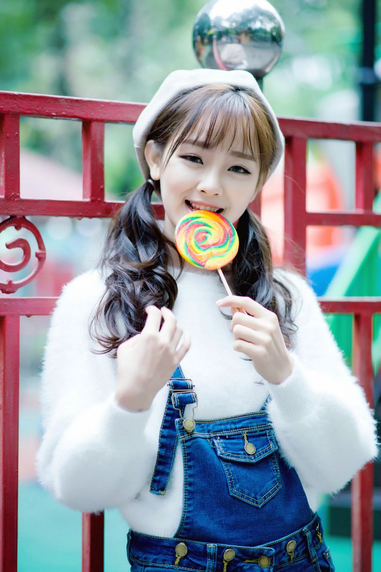 有着清新笑容手拿棒棒糖如天使般美丽的女孩
