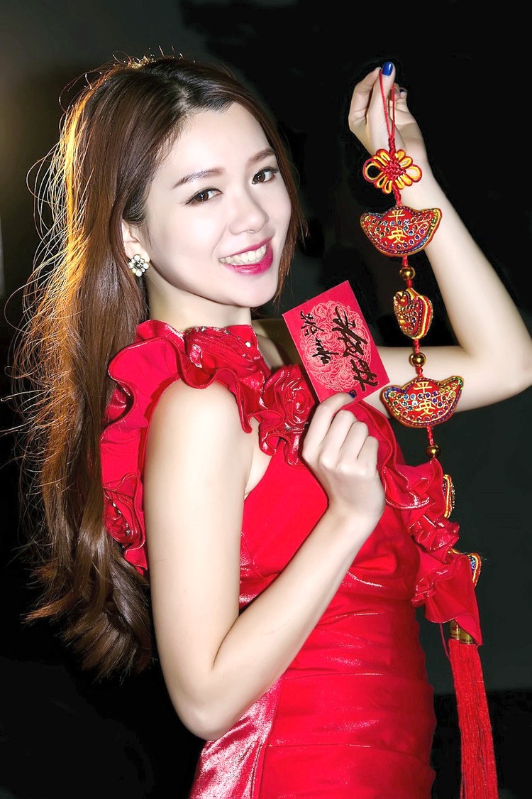 新年夜空下一个露出开心笑容的美丽红裙美女