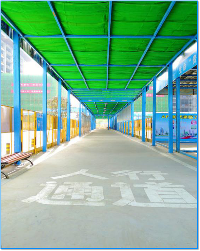 图为施工现场装配式安全通道,两侧贴满了安全生产操作规程等宣传资料