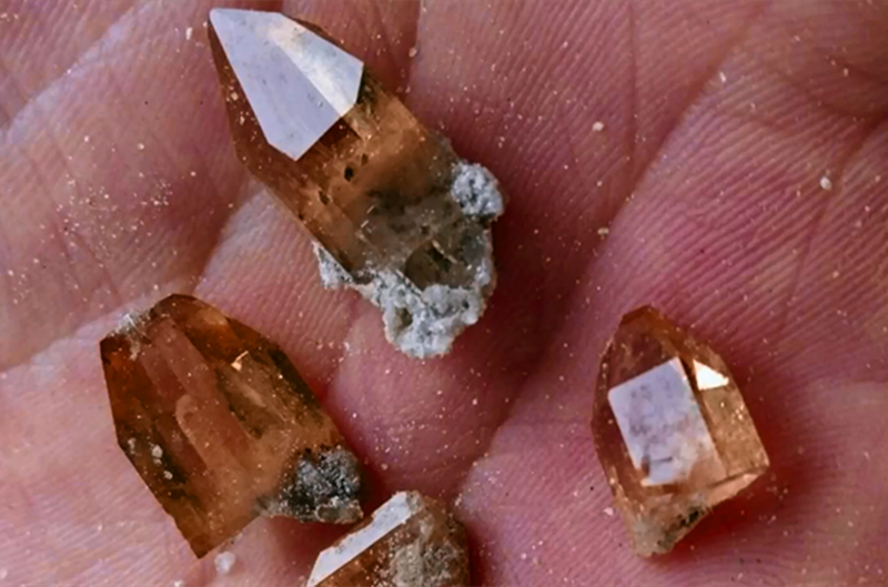 伟晶岩中,它是一种具有玻璃光泽的透明斜方晶体,常见颜色为无色和黄色