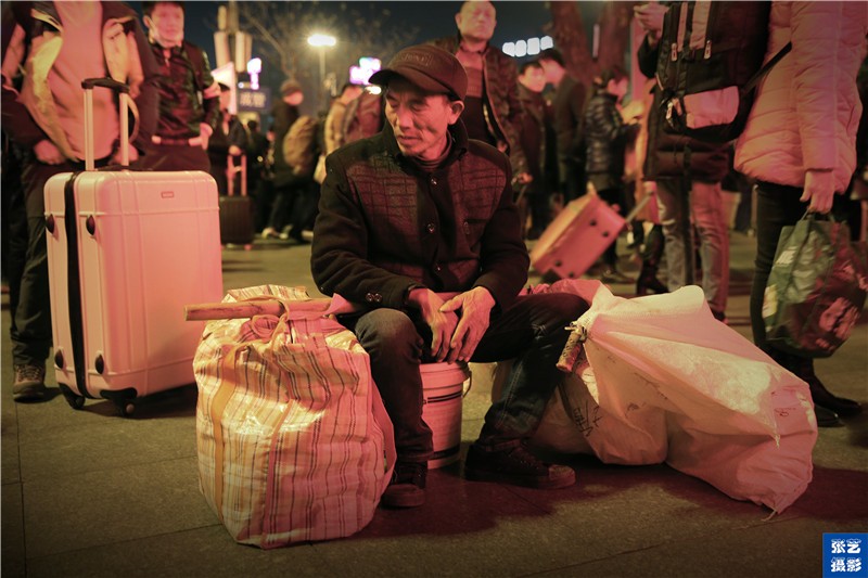 也有在建筑工地上打工的外来工,坐在自己带来的塑料桶上.