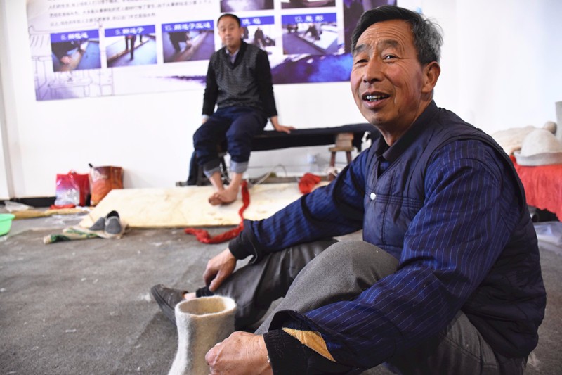 在一间普通的平房里,地上堆着不少羊毛,刘树旺师徒二人正忙着擀毡