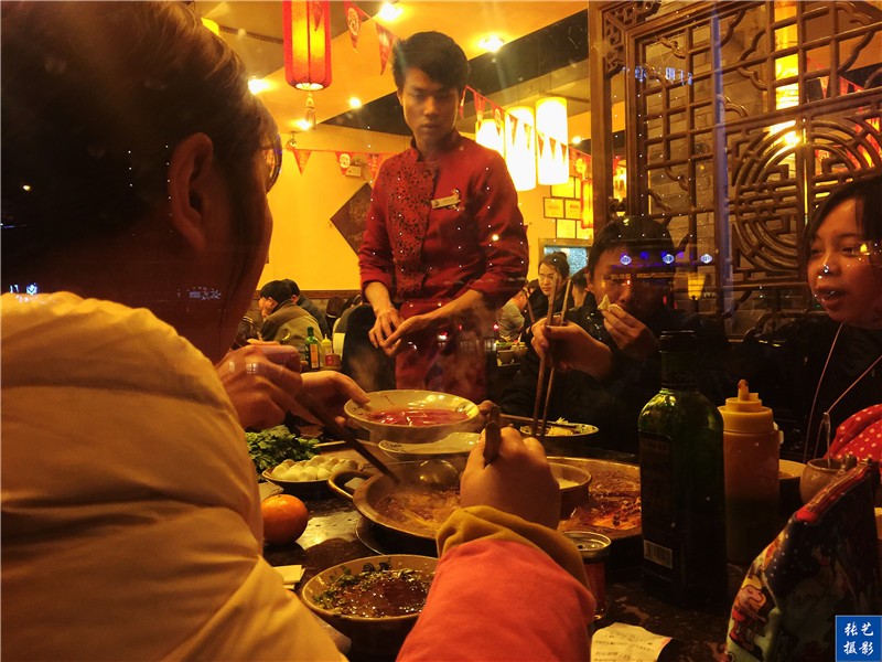 火锅店外客人寒风刺骨烤火盆,火锅店内热气腾腾,热闹非凡,客人们吃的
