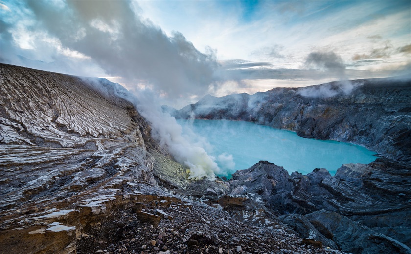 摄影师在印尼的蓝色火山上为新人拍摄婚纱照