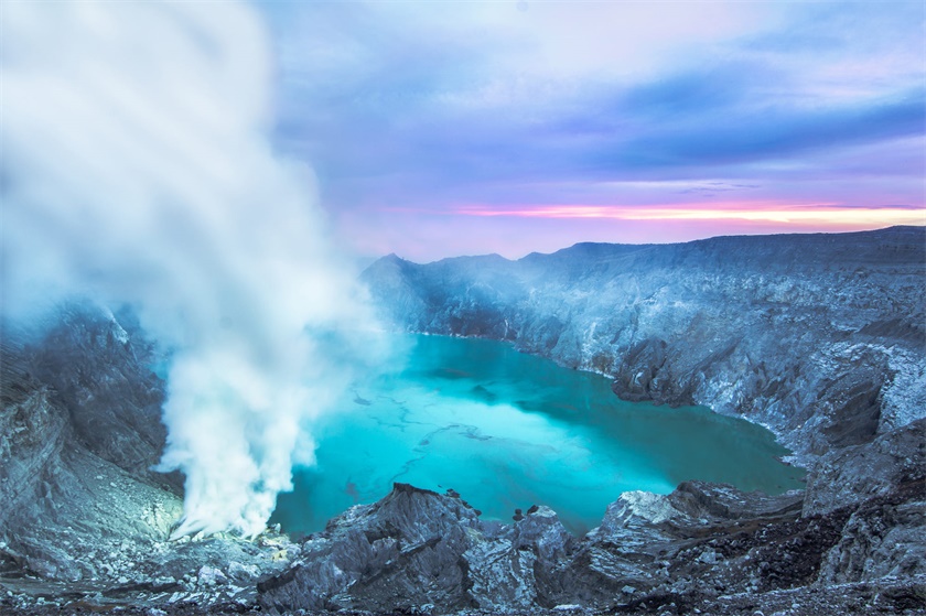 摄影师在印尼的蓝色火山上为新人拍摄婚纱照