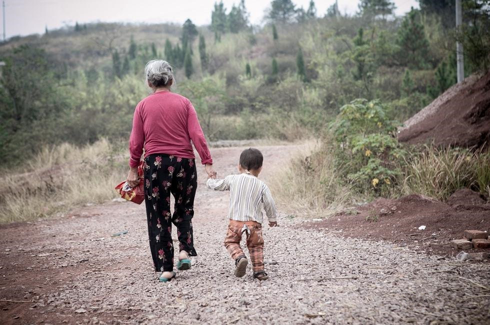 这是牛老汉的老伴王奶奶,每天王奶奶都要走几公里的山路,带着小孙子