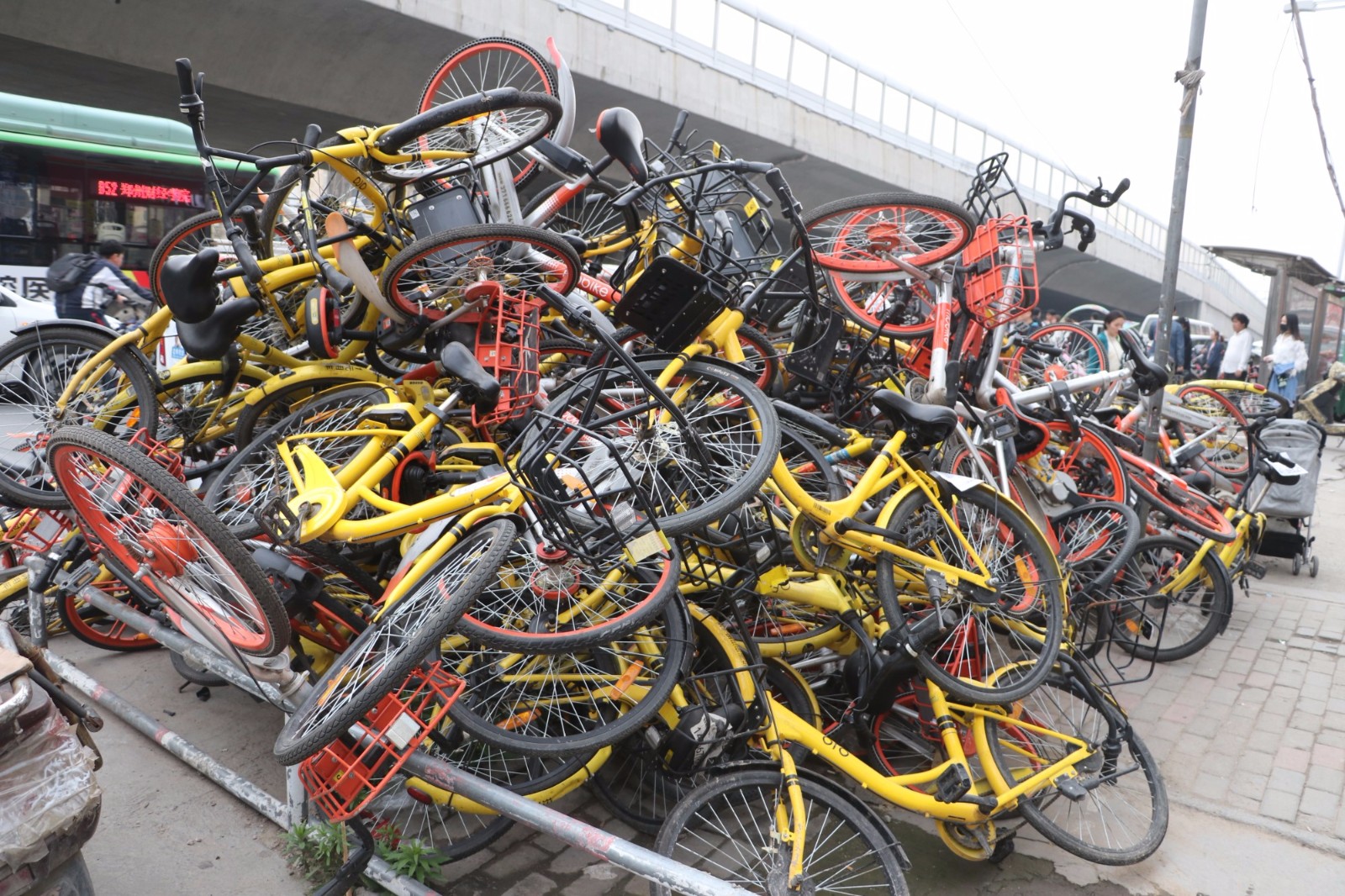 郑州街头共享单车堆成了小山成坟场,耀眼又刺眼