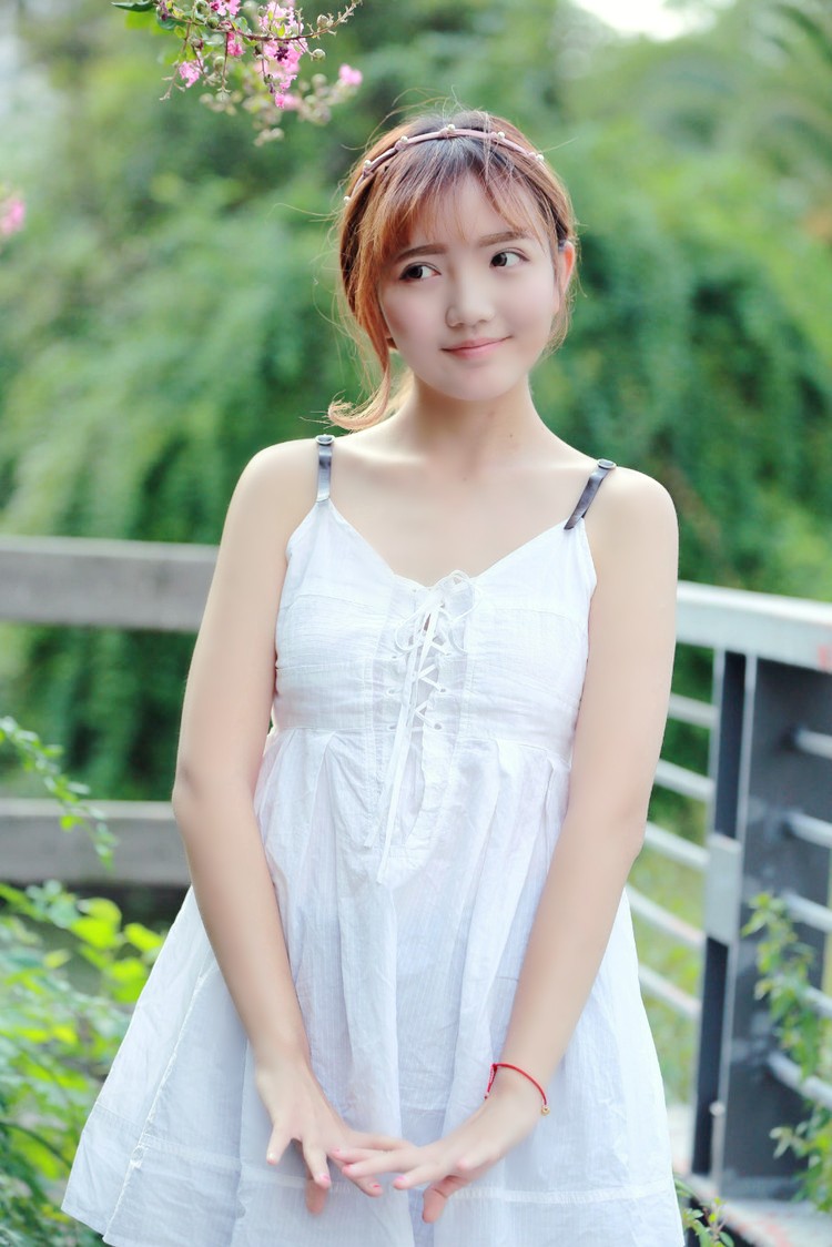 阳光下一个秀丽可爱的美裙姑娘