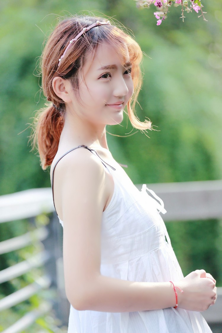 阳光下一个秀丽可爱的美裙姑娘