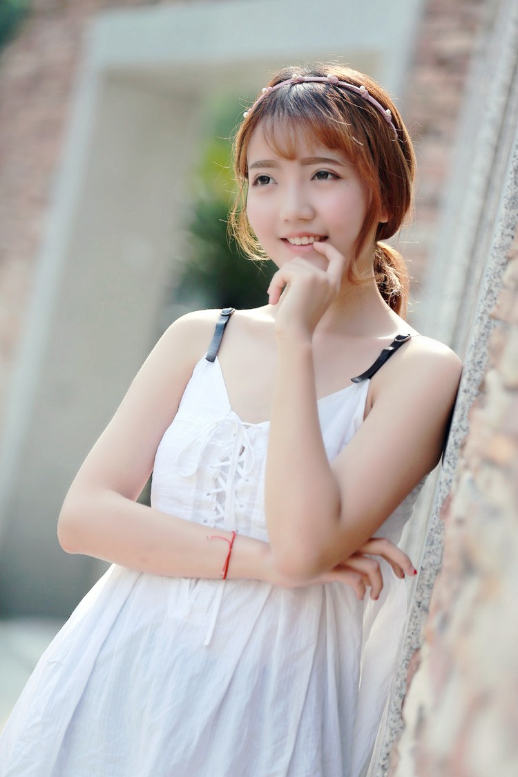 阳光下一个秀丽可爱的美裙姑娘