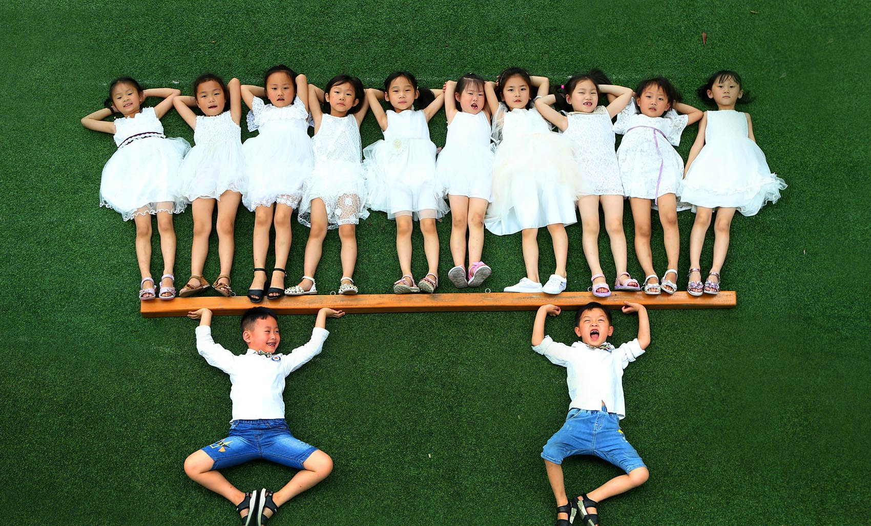 操场上处处洋溢着欢乐氛围的,孩子们穿上漂亮的服装,在老师和摄影师的